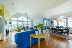 a living room with a blue couch and a table at Crow's Nest - Corolla, Crown Point, 150 Yds to Beach, Hot Tub, Community Pool, Pets OK in Corolla
