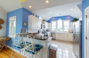 a kitchen with blue walls and white cabinets at Crow's Nest - Corolla, Crown Point, 150 Yds to Beach, Hot Tub, Community Pool, Pets OK in Corolla