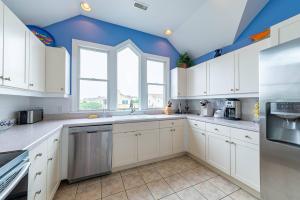 a kitchen with white cabinets and a blue ceiling at Crow's Nest - Corolla, Crown Point, 150 Yds to Beach, Hot Tub, Community Pool, Pets OK in Corolla +46 photos