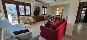 a living room with two red chairs and a couch at Luminous Apartment in Agia Triada
