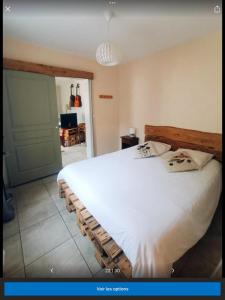 a bedroom with a large white bed with two pillows at Le petit Flotteur in Chevroches