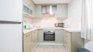 a white kitchen with white cabinets and a microwave at Sweet Home by Toledo AP in Toledo