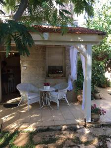 a patio with a table and chairs under a pavilion at נופש בפינה in Rosh Pinna