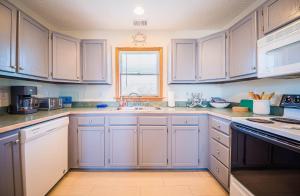 a kitchen with white cabinets and a sink and a window at Beach Place - Corolla, Ocean Sands, 370 Yards to the Beach, Flex Stays, Pets OK, Pool! in Corolla