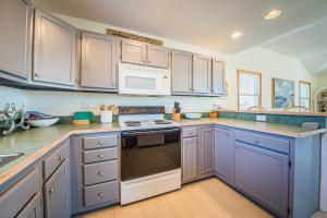 a kitchen with blue cabinets and a stove top oven at Beach Place - Corolla, Ocean Sands, 370 Yards to the Beach, Flex Stays, Pets OK, Pool! in Corolla