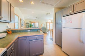 a kitchen with purple cabinets and a white refrigerator at Beach Place - Corolla, Ocean Sands, 370 Yards to the Beach, Flex Stays, Pets OK, Pool! in Corolla +34 photos