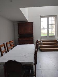a dining room with a table and chairs and a window at Maison Cyril in Eurville