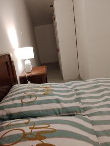 a bedroom with a bed and a lamp on a table at Maison Cyril in Eurville +3 photos