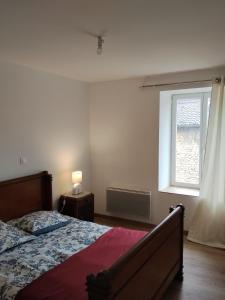 a bedroom with a bed and a window at Maison Cyril in Eurville