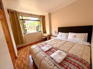 a bedroom with a large bed and a window at Aruma Andina Hotel CHAVÍN in Chavín de Huantar