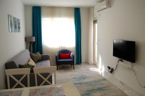 a living room with a couch a chair and a television at Yeshill Deluxe Apartment in Budva