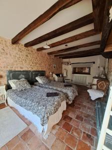 two beds in a room with a brick wall at maison la Bambine chambre esprit château in Ozolles