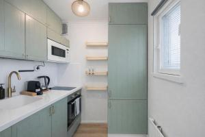 a kitchen with green cabinets and a sink at Katariina Apartments in Kotka