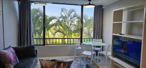 a living room with a table and a large window at Breakers Resort Apartment 314 in Durban