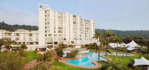 a large hotel with a pool in front of a building at Breakers Resort Apartment 314 in Durban +6 photos