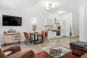 a living room with a table and a kitchen at Ferienwohnungen "Godewind", Appartements mit Balkon oder Terrasse in Zinnowitz