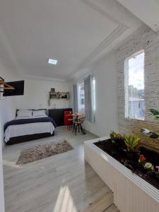 a bedroom with a bed and a table in a room at Suíte Garden em Butantã Próximo á USP - Self Check-in in São Paulo