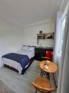 a small bedroom with a bed and a table at Suíte Garden em Butantã Próximo á USP - Self Check-in in São Paulo +2 photos