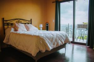 a bedroom with a bed with a view of a balcony at La Magia del Bosque in Puebla