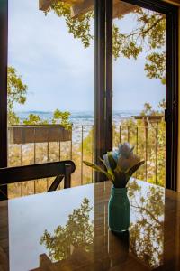 a vase with flowers on a table in front of a window at La Magia del Bosque in Puebla