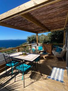 a patio with a table and chairs on a deck at Mobil-home Premium Côte d'Azur Camping 4 étoiles Saint-Raphaël Piscines Climatisation Vue mer et Parking in Saint-Raphaël