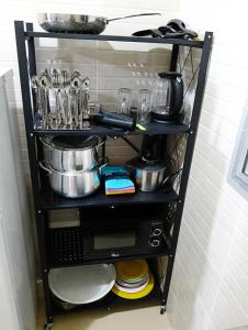 a shelf with pots and pans on it in a kitchen at GALSEN LODGe in Thiès