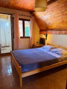 a bedroom with a large bed with a wooden ceiling at Bungalow Hostel Iguazú in Puerto Iguazú
