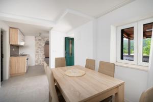 a kitchen and dining room with a wooden table and chairs at Holiday house with heated pool in Neorić