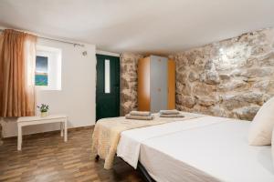 a bedroom with two beds and a stone wall at Holiday house with heated pool in Neorić +21 photos