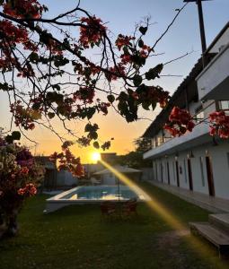 Sonnenuntergang über einem Innenhof mit Stühlen und einem Pool in der Unterkunft Pousada Mali in Canoa Quebrada