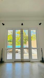 an empty room with three doors with windows at Villa Mario in Unawatuna