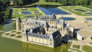 an aerial view of a castle in the water at La loge Diane, à deux pas du château et son jardin à la française in Chantilly