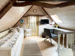 a bedroom with a bed and a desk in a attic at Emmis-Ferienhaus in Dörpling