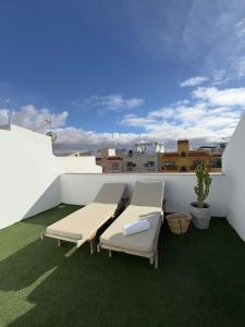 a patio with two chairs and a table on a roof at Bel Air Surf Escape in El Cotillo