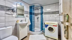 a bathroom with a toilet sink and a washing machine at Maja Pokoje z Widokiem in Mirsk +41 photos