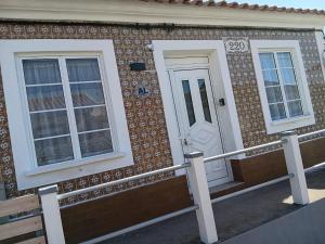 a house with two windows and a white door at Raiz Atlântica in Angra do Heroísmo
