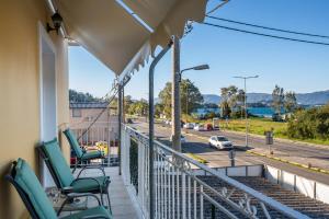 a balcony with chairs and a view of a street at Ioana Sea View in Corfu