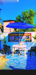 a table with a blue umbrella on a patio at Lonavala Golden Bird 3 bhk villa in Malavli