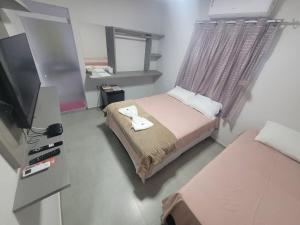 a small bedroom with a bed and a television at Pousada Novo Millenium in Araripina +40 photos