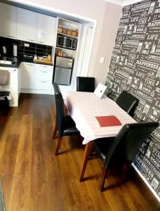 a kitchen with a table and chairs in a kitchen at B&B on Station in Paeroa