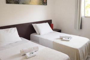 two beds in a room with white sheets at Che Lagarto Paraty in Paraty +29 photos