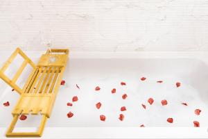 a wooden chair next to a bath tub with leaves at Atelier AS in Voluntari