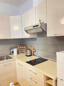 a kitchen with white cabinets and a stove top oven at Roy Apartments in Durrës