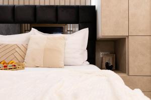 a bed with white pillows and a basket of fruit on it at Atelier AS in Voluntari +25 photos
