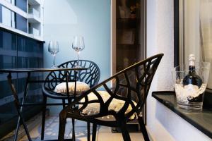 a balcony with two chairs and a table with wine glasses at Atelier AS in Voluntari