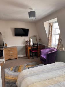 a bedroom with a bed and a tv and a chair at Bristol Old City Studio in Bristol