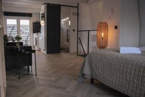 a bedroom with a bed and a desk and a bathroom at Loft 15 in Alkmaar