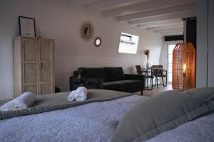 a bedroom with a bed and a living room at Loft 15 in Alkmaar