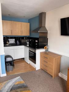 a kitchen with white cabinets and a black stove at Bristol Old City Studio in Bristol