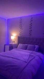 a purple bedroom with a large bed with purple lighting at Salve habitación in Estepona